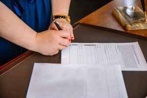 Person filling out legal documents for property regularization - Photo by Unsplash