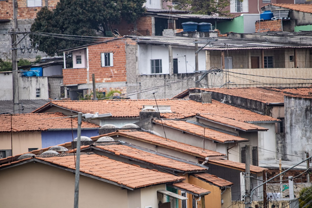 Bairro brasileiro com casas em diferentes estágios de construção representando imóveis irregulares que precisam de regularização