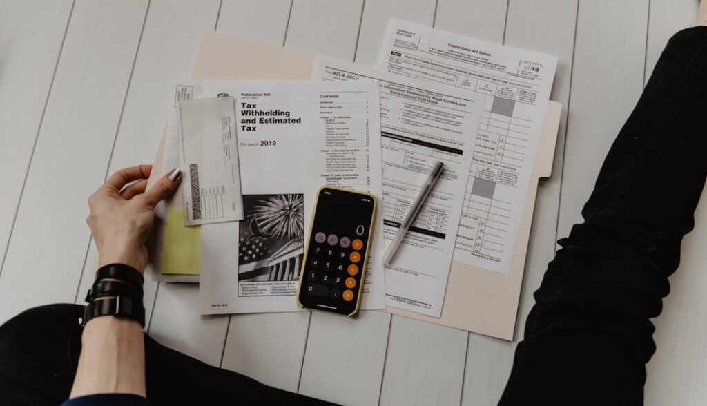 Person calculating legal fees with documents, calculator and pen on desk representing budget planning for legal services