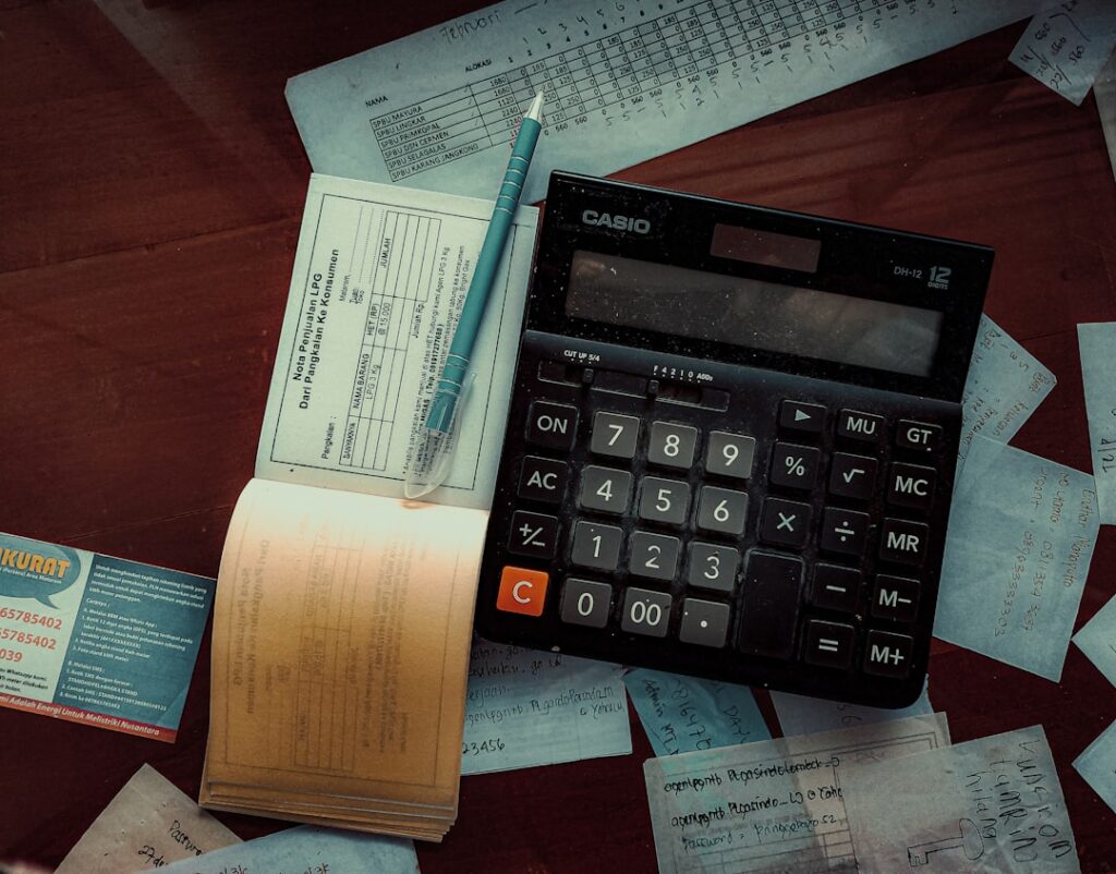 Calculator with financial documents representing property debt calculations