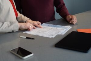 Two professionals reviewing legal contract documents during a business meeting - Photo by Unsplash