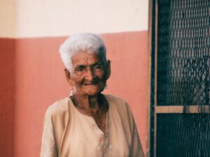 Idosa com cabelos brancos sorrindo — benefícios assistenciais ao idoso pelo INSS