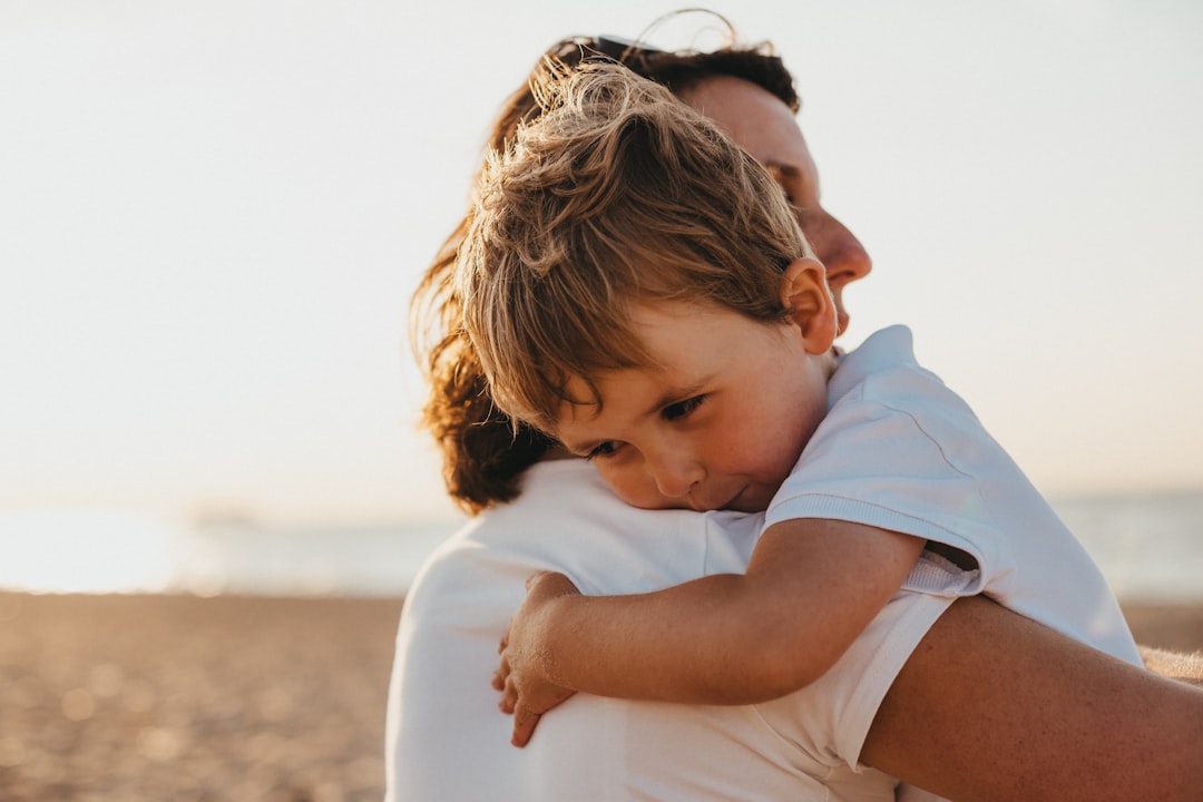 Pai segurando filho no colo na praia — ilustração de vínculo parental e pensão alimentícia