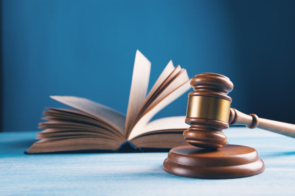 Martelo da justiça e livro aberto representando direitos legais do consumidor no distrato imobiliário