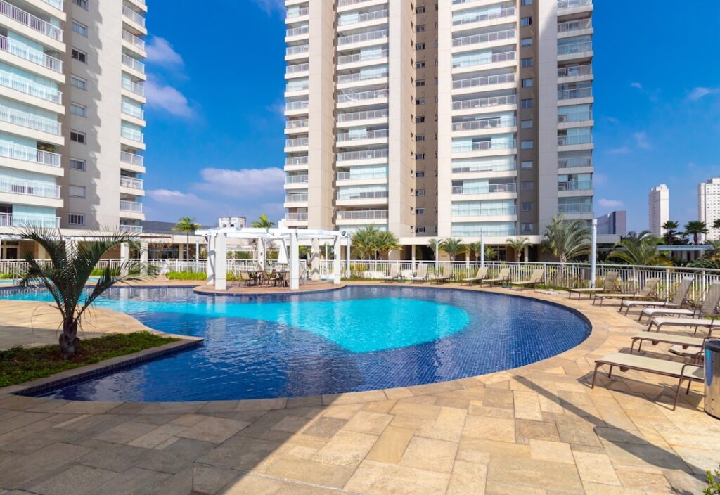 Condomínio residencial moderno com piscina e torres de apartamentos representando investimento imobiliário
