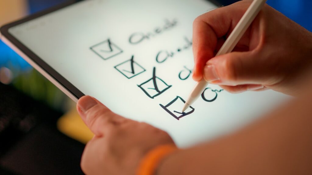 Pessoa preenchendo checklist digital em tablet para avaliar critérios de qualidade