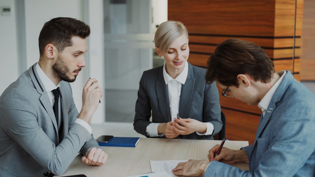 Consulta jurídica profissional com advogado explicando detalhes contratuais para clientes em escritório moderno