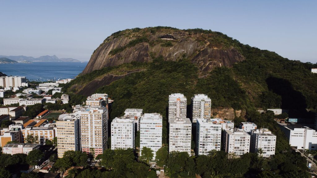 Vista aérea de prédios residenciais no Rio de Janeiro com morro ao fundo, representando o mercado imobiliário carioca