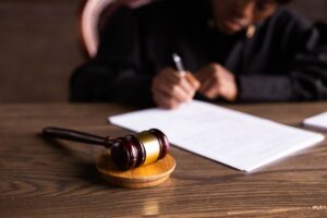 Juíza assinando documentos com martelo judicial em primeiro plano, representando a execução de alimentos no direito de família