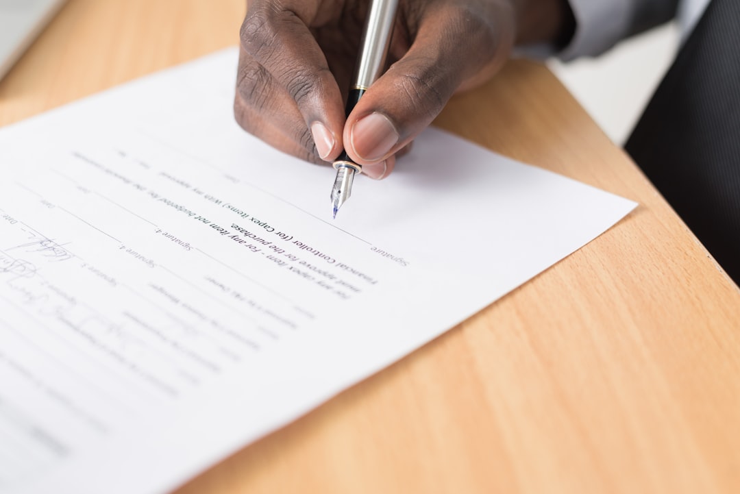 Mão assinando documento de contrato imobiliário — distrato imobiliário no Centro do Rio de Janeiro