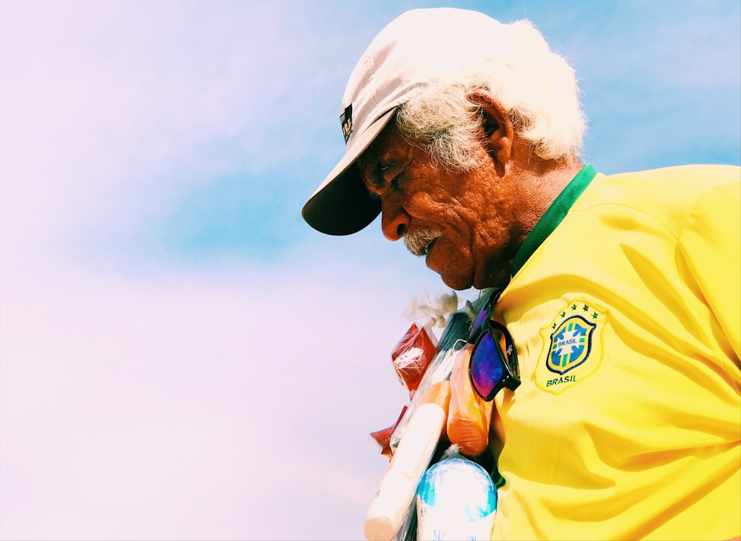Idoso brasileiro com camisa da seleção representando o trabalhador que busca aposentadoria pelo INSS em Jacarepaguá, Rio de Janeiro