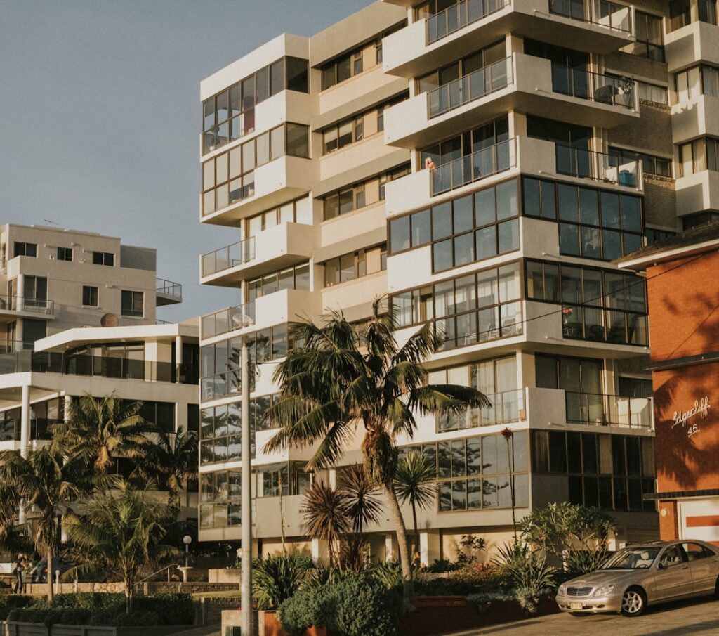 Edifício residencial de alto padrão com palmeiras, representando o mercado imobiliário do Leblon