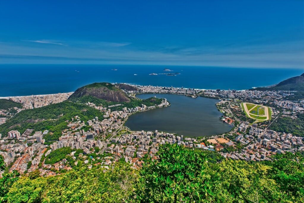 Vista aérea do Rio de Janeiro com lagoa, montanhas e bairros da Zona Oeste ao fundo