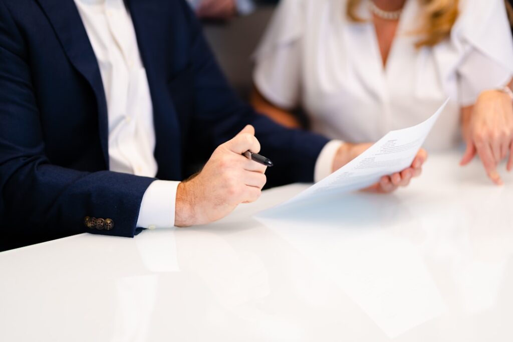 Advogado e cliente analisando documentos de contrato imobiliário em reunião profissional