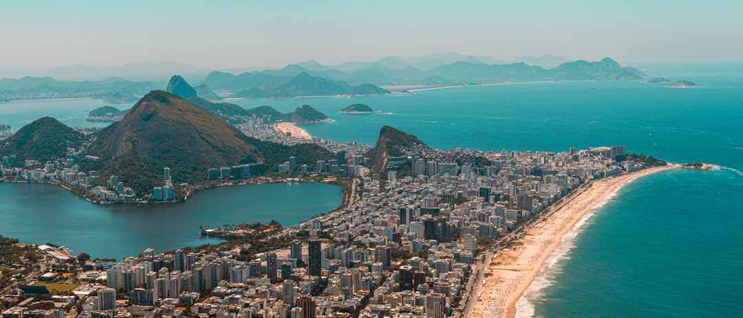 Vista aérea do Rio de Janeiro com prédios, praia e montanhas ao fundo, representando o mercado imobiliário carioca
