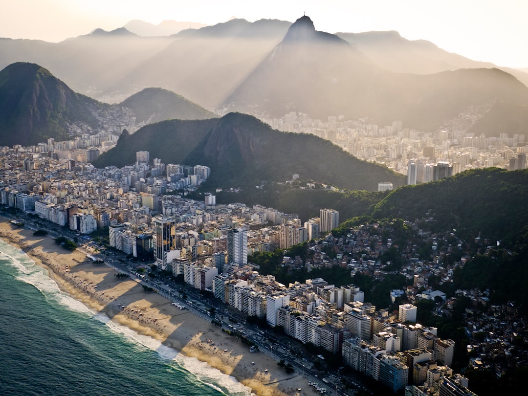 Vista aérea do Rio de Janeiro com a praia, edifícios e montanhas ao fundo, representando o cenário patrimonial de Ipanema para planejamento sucessório