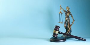 Martelo da justiça e estátua da balança da justiça sobre fundo azul, representando advocacia previdenciária